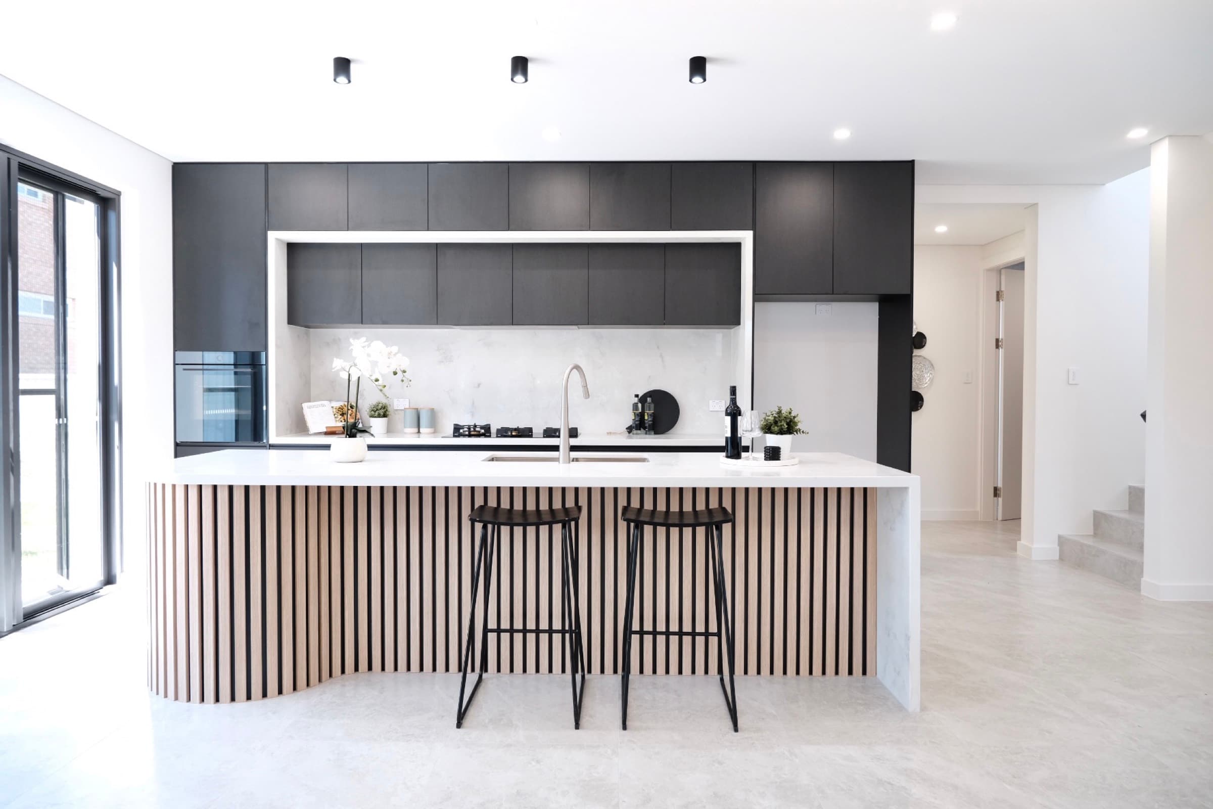 Contemporary kitchen with stone island bench and bar stools